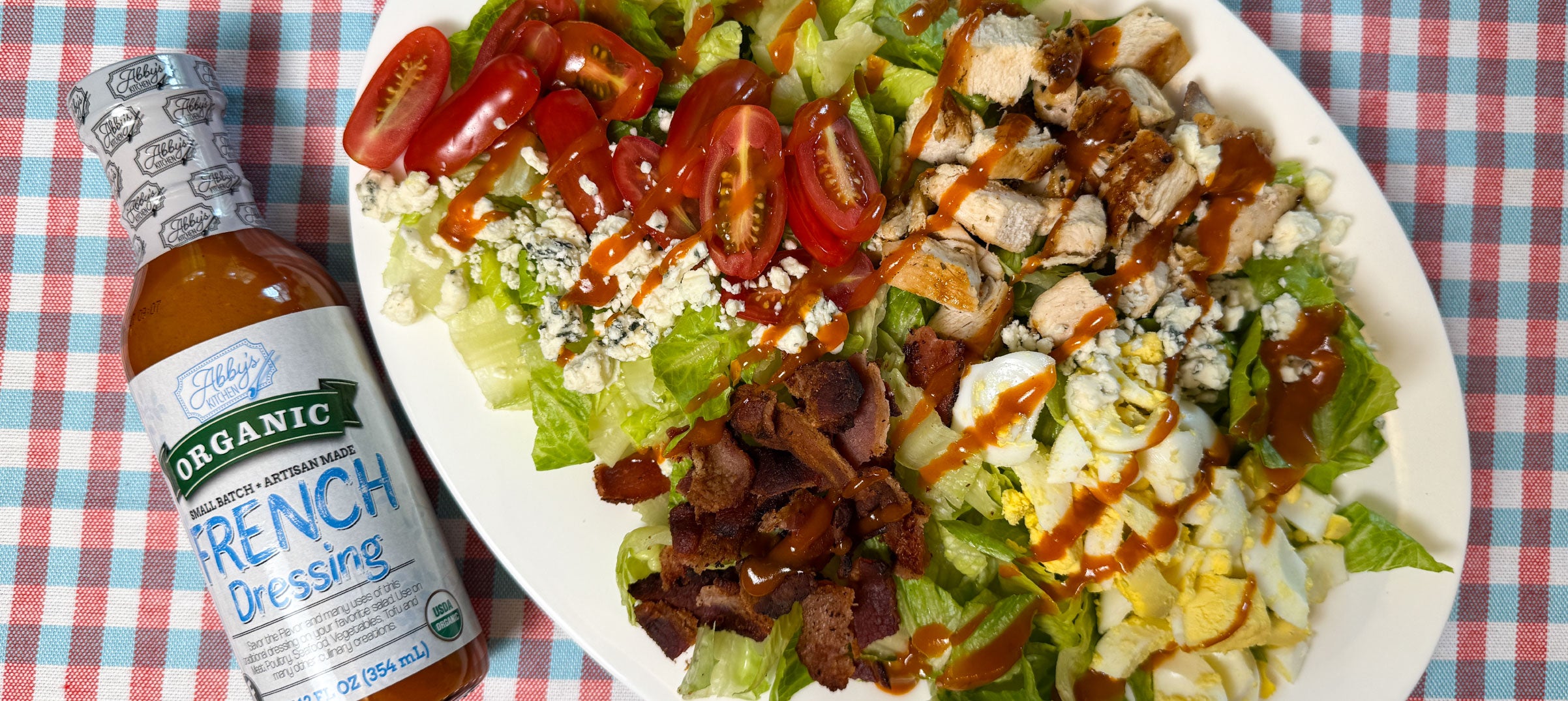 Grilled chicken cobb salad with a bottle of Abby's Kitchen French Dressing